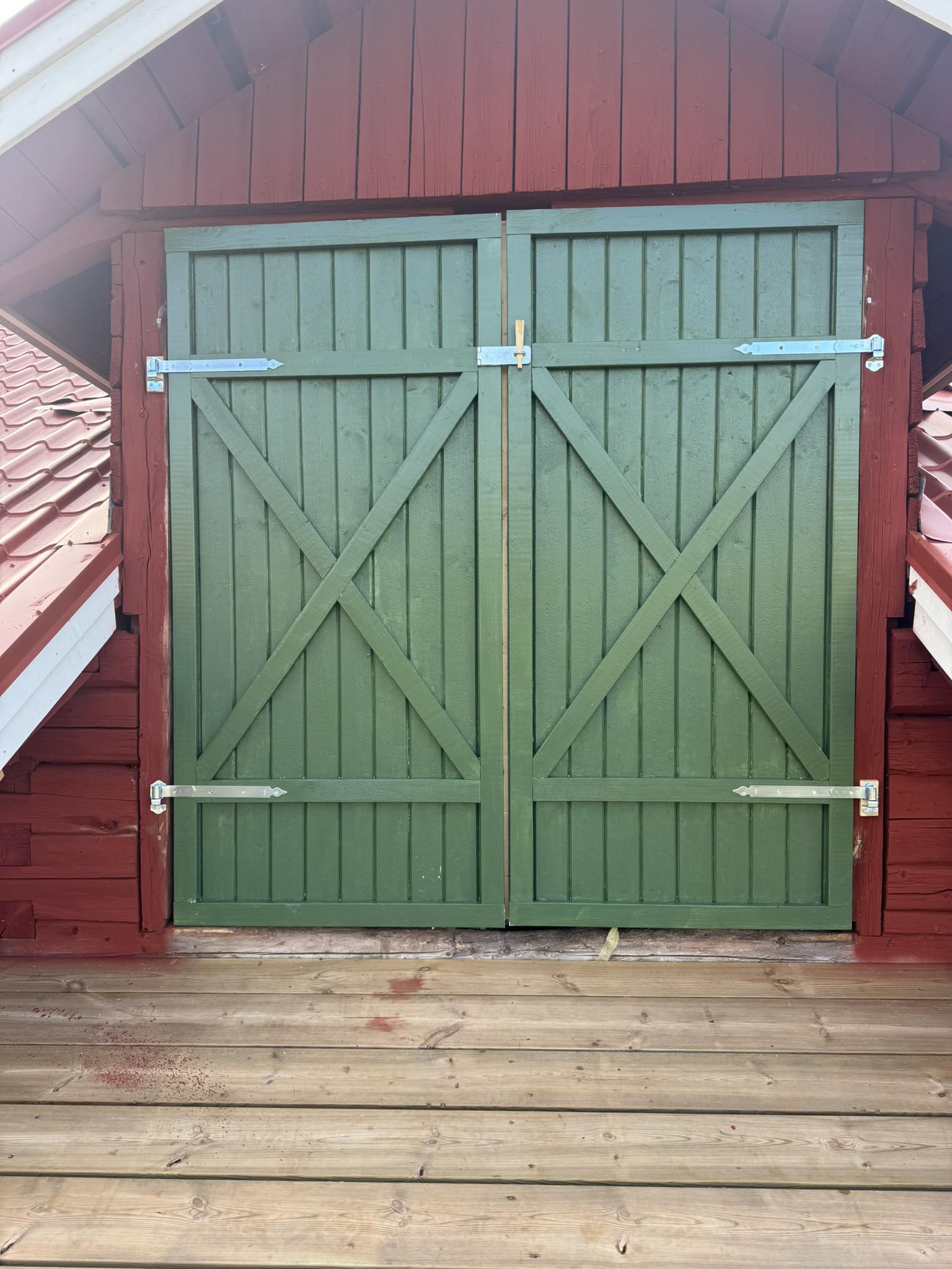 Grön dubbelport på ladugård — träarbete av Norderö Byggtjänst